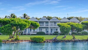 A waterfront property with a pool, a two-story building with balconies, and well-maintained landscaping. - Duck Key Townhome on open Water (Duck Key)