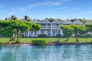 A waterfront property with a pool, a two-story building with balconies, and well-maintained landscaping. - Duck Key Townhome on open Water (Duck Key)