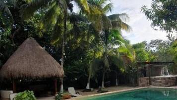 Una piscina al aire libre, sillones reclinables de piscina