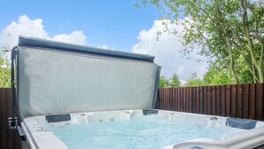 A hot tub with a wooden deck and a wooden fence in the background. - 1 Clarkes Lane (Oswestry)