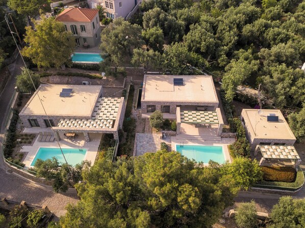 A residential area with multiple houses, each featuring a rooftop pool and outdoor seating areas. - Ouzo Stone House1 with Private Pool and Parking (Agios Isidoros)