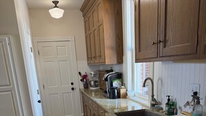 A kitchen with wooden cabinets, a stainless steel dishwasher, and a granite countertop.
