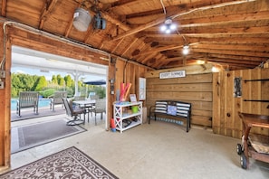 A wooden interior with a pool area, outdoor seating, and a sign that reads 'EVERY SUMMER IS A SUMMER.'