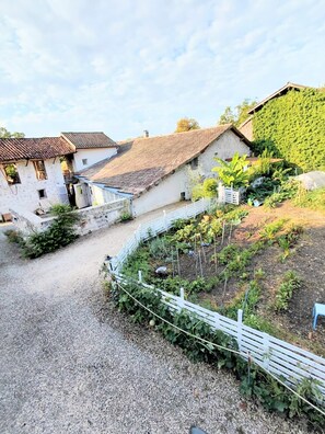 A rural property with stone buildings, a gravel driveway, and a fenced garden area. - Chalet-style, detached cottage in a quiet rural setting (Voiron)