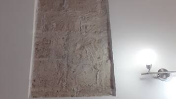 Une pièce avec un sol blanc et une partie du mur présentant une texture particulière.