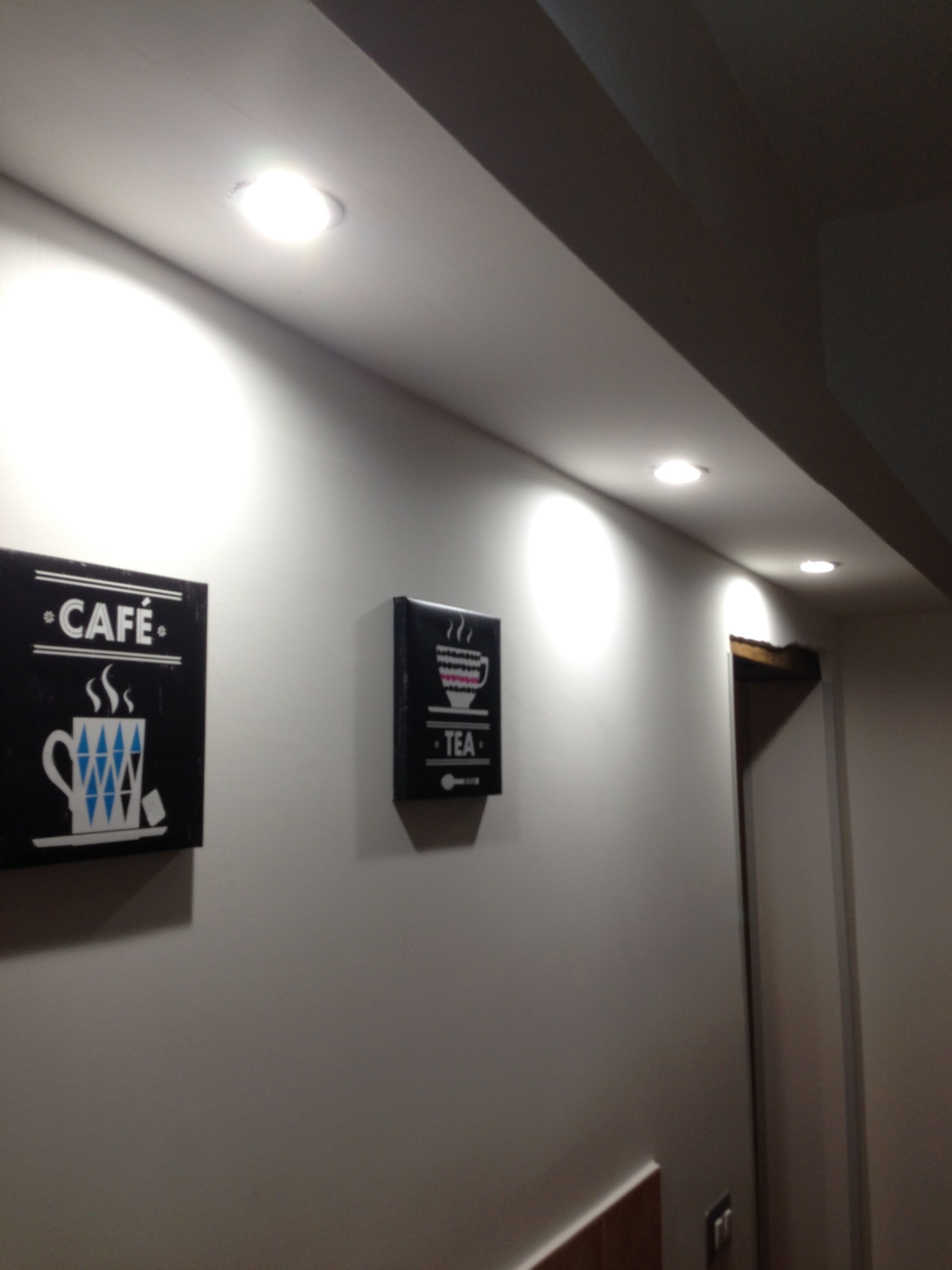 A hallway with two signs on the wall, one labeled 'CAFE' and the other 'TEA'.