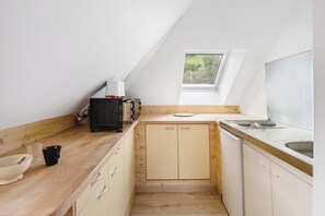 A compact kitchen with wooden countertops, a built-in microwave, and a window above the sink. - T2 on the second floor in the Welche region. (Lapoutroie)