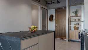 Eine moderne Küche mit Marmorarbeitsplatte, Obstschale und Holztür.