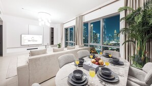 Un comedor moderno con vistas a la ciudad, un televisor y una planta.