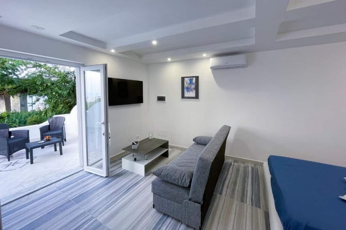 Un soggiorno moderno con un divano, un tavolino da caffè e una TV a parete.