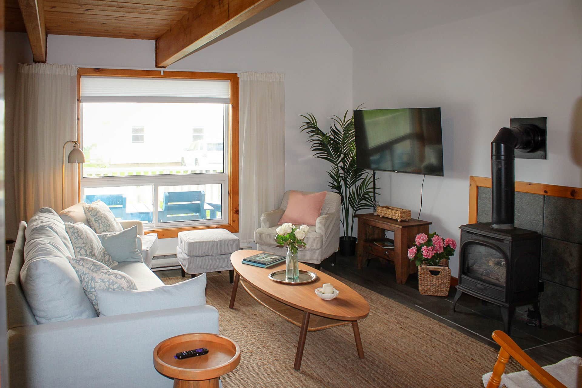 Un salon confortable avec un canapé, des fauteuils, une table basse, une cheminée et un téléviseur.