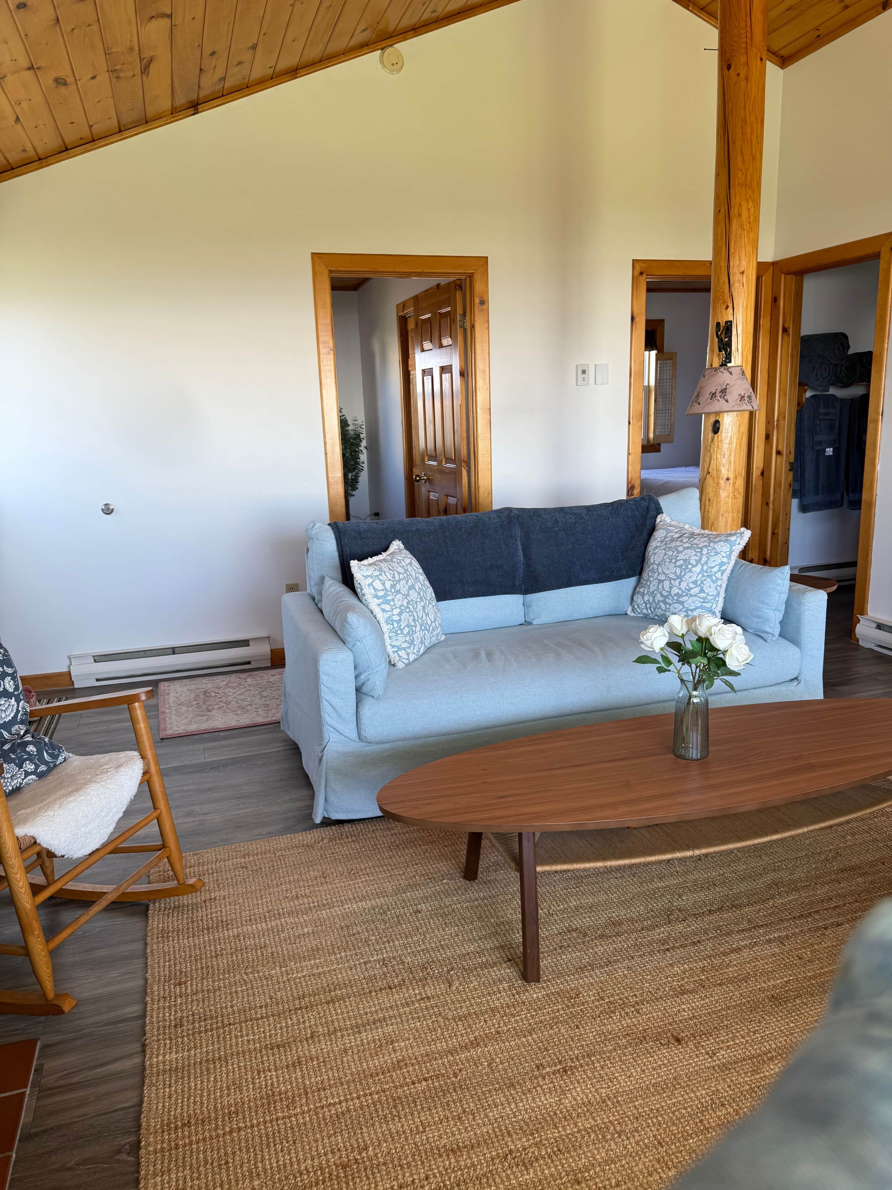 A living room with a light blue sofa, a wooden coffee table, and a rocking chair.