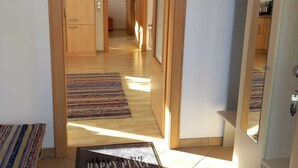 A hallway with wooden doors, a rug, and a welcome mat. - House at the edge of the forest Thiersee (Thiersee)