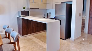 Una cocina moderna con una isla central, electrodomésticos de acero inoxidable y un diseño minimalista.
