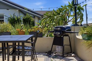 An outdoor patio with a grill, a table, chairs, and potted plants. - Canal-Front Pool Home Near Gulf Beaches & Golf (Rotonda West)