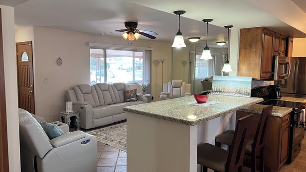 A modern kitchen with granite countertops, a central island, and dark wooden cabinets. - Serene 3-bedroom house in Sun City
Golf course & lake front near Stadium. (Sun City)