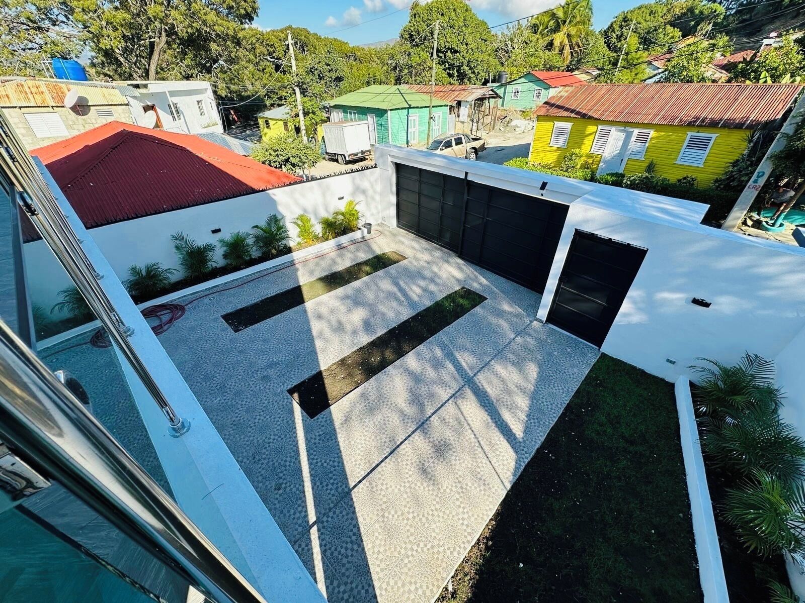 Ein modernes Gebäude mit Innenhof, befestigtem Boden und kleinem Gartenbereich.