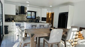A modern kitchen with white cabinets, a granite countertop, and a built-in oven.