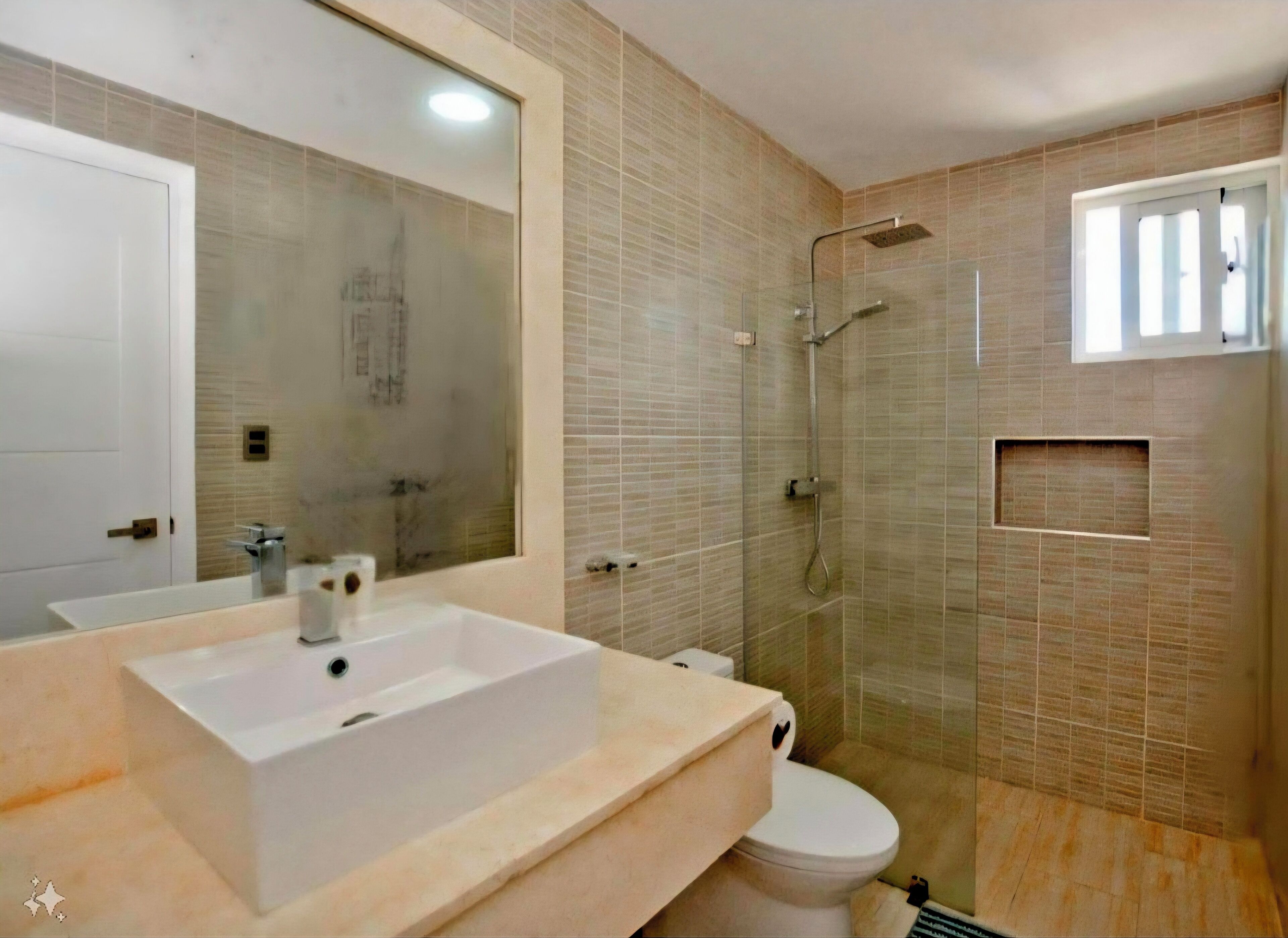 Ein Badezimmer mit einem großen Spiegel, einem weißen Waschbecken, einer Toilette und einer Duschkabine.