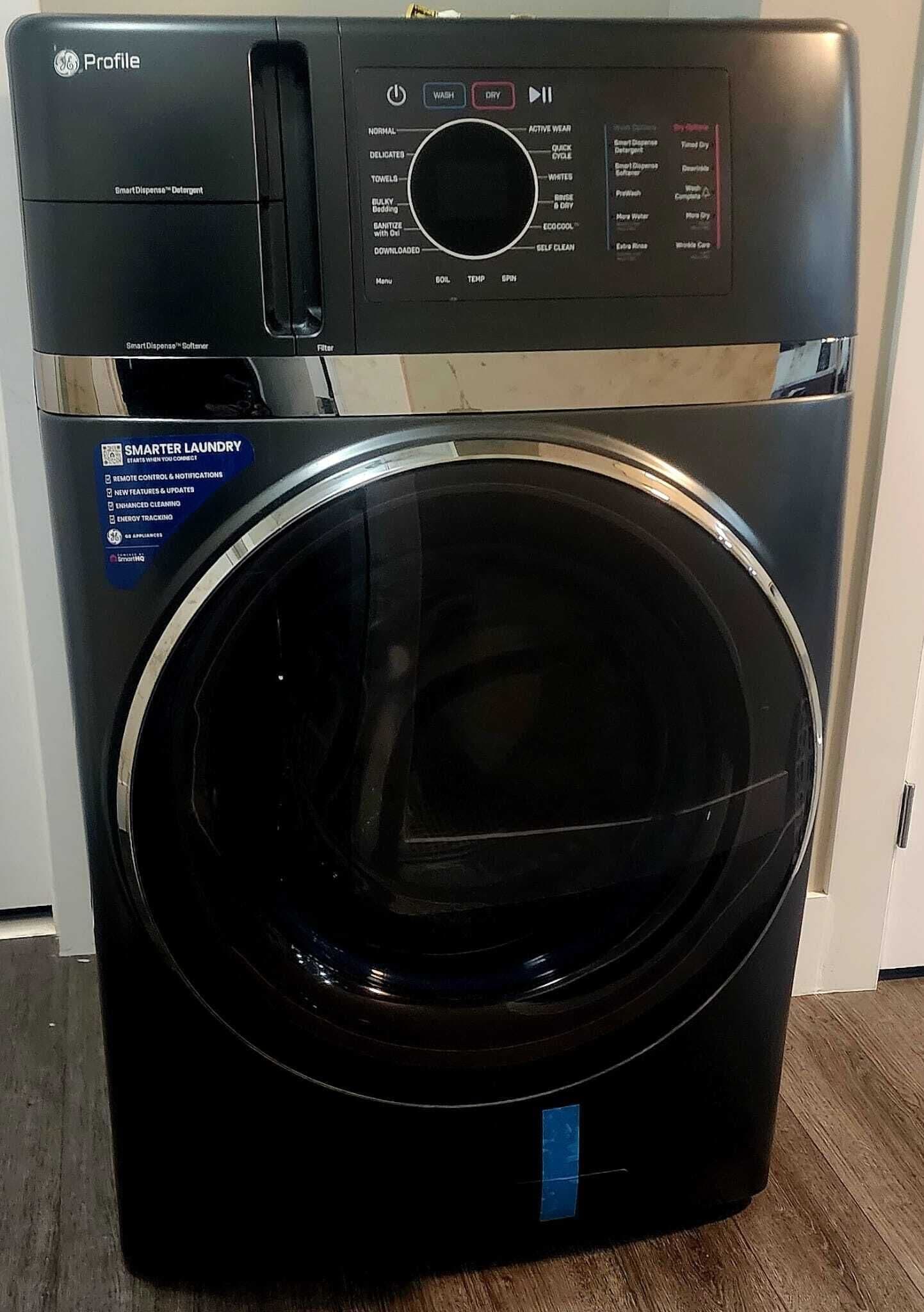 A front view of a GE Profile Smart Dispenser washer with a black front panel and a stainless steel top.