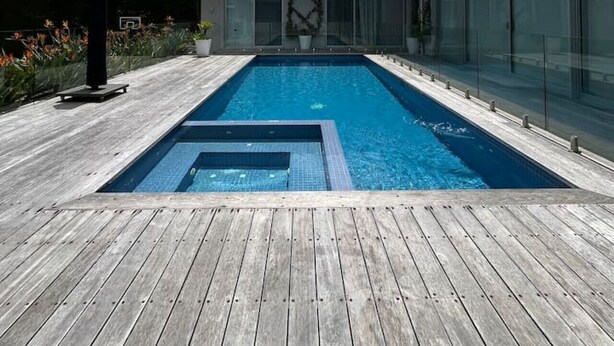 A modern house with a rectangular swimming pool surrounded by a wooden deck. - Portsea Paramount - when only the best will do! (Portsea)