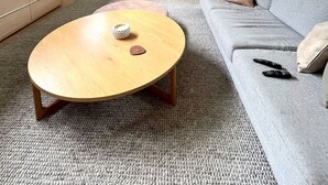 A modern living room with a grey sofa, a wooden coffee table, and a fireplace. - Portsea Paramount - when only the best will do! (Portsea)