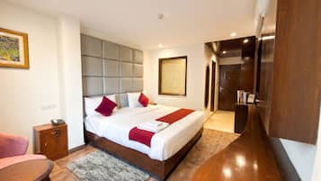 Una habitación de hotel moderna con una cama grande, una mesita de noche, una silla, un escritorio y un armario.