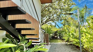 A modern building with a wooden facade and a gravel pathway leading to a covered area. - New studio in awesome Dominical walk to the beach in center of town, security AC (Dominical)
