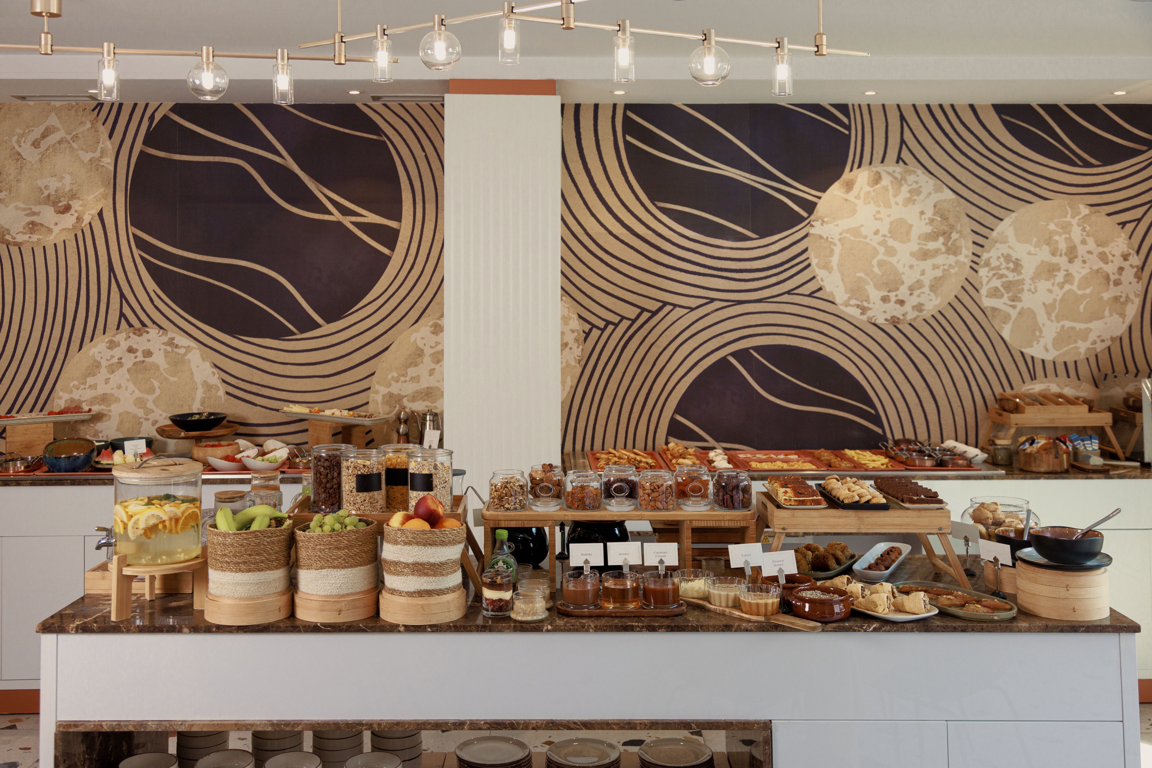 A buffet with various food items and beverages, including fruits, nuts, and desserts.