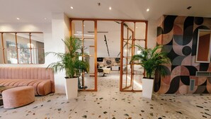 Um interior moderno com área de estar, espaço para refeições e uma parede decorativa.