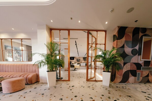 Um interior moderno com área de estar, espaço para refeições e uma parede decorativa.