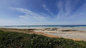 Een strand met een heldere lucht en golven.