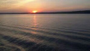 Ein Sonnenuntergang über ruhigem Wasser.