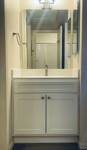 A bathroom with a white vanity, a mirror, and a shower curtain. - 1 BR Condo, Top Floor, Gated Community, Pool/Spa, Exercise Room, Covered Parking (Tucson)