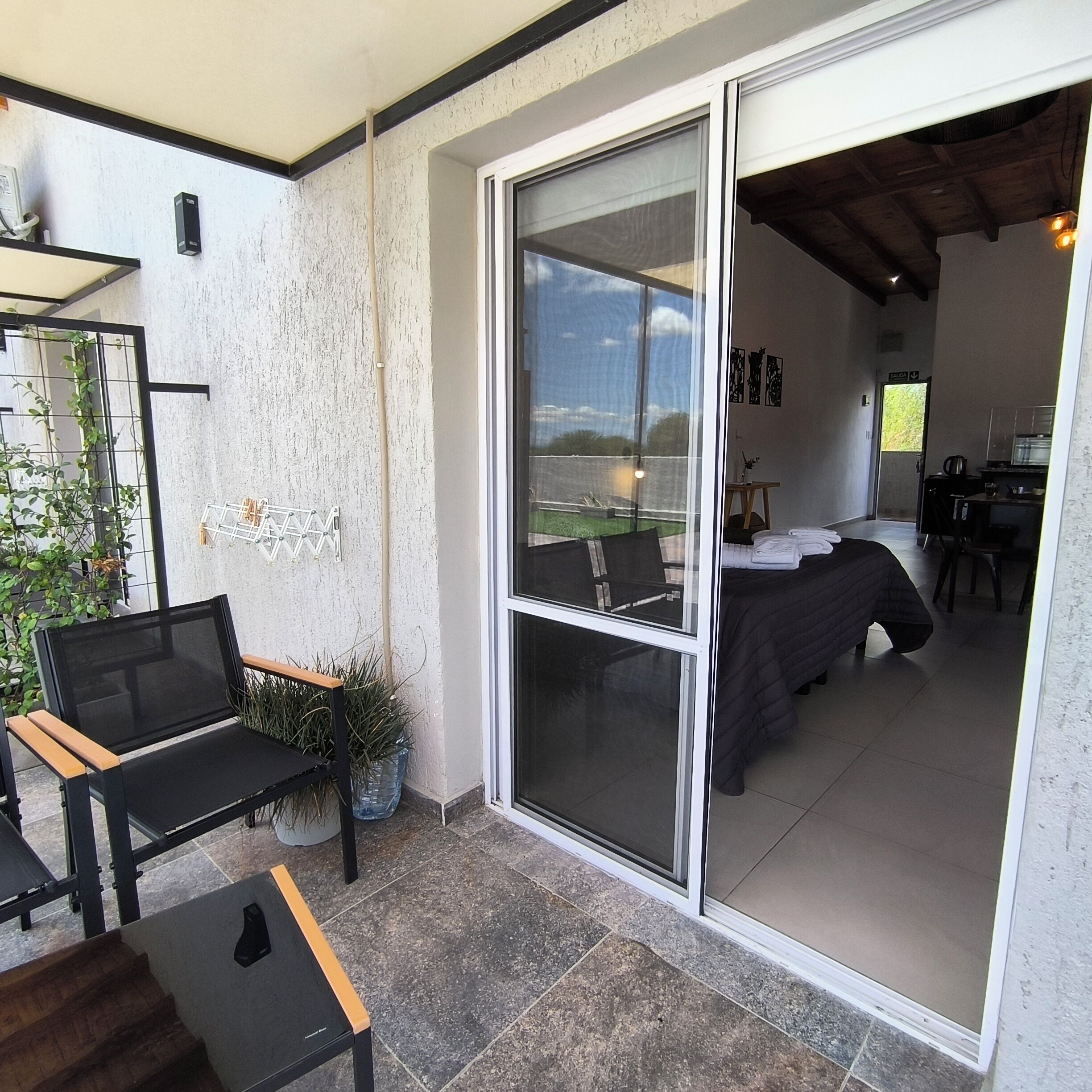 A room with a bed, a desk, and a view of the outdoors.