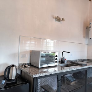 A compact kitchen with a built-in toaster oven, a kettle, and a sink. - Close to everything! Merlo S Luis Apartment for Couples Spacious, Bright, Modern (Merlo)