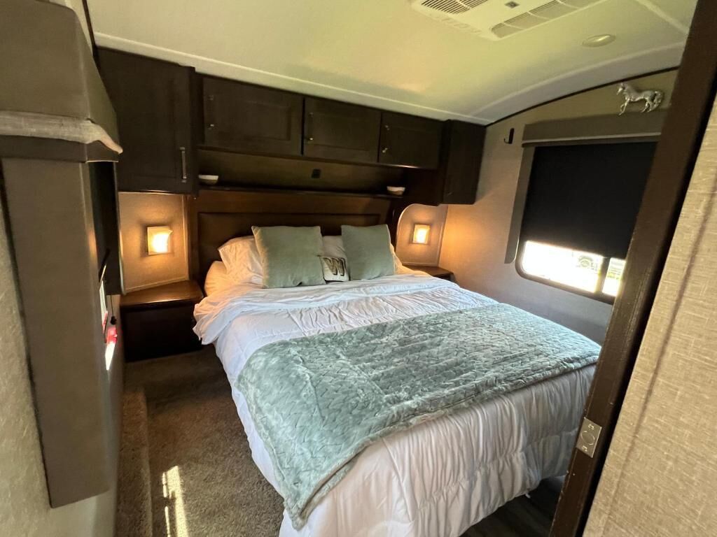 Une chambre à coucher comprenant un lit, des tables de chevet et des armoires encastrées.