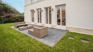 A modern house with a patio area featuring outdoor furniture and a well-maintained lawn. - Villa Nova Berlin: Modern vacation home with plenty of space for relaxation and comfort (Berlin)