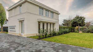 A modern two-story house with a paved driveway and a well-maintained lawn. - Villa Nova Berlin: Modern vacation home with plenty of space for relaxation and comfort (Berlin)