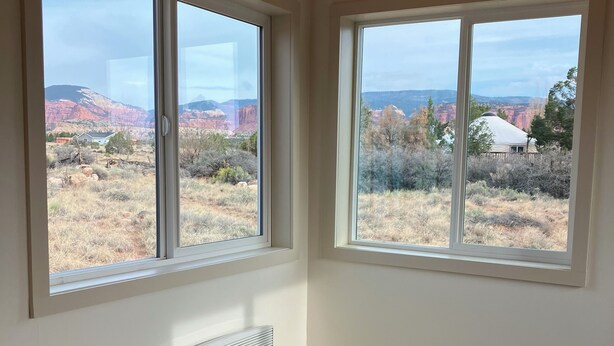 A room with two large windows offering views of a mountainous landscape. - Sunny & Private I bedroom House with Sun Room for Guests (Torrey)