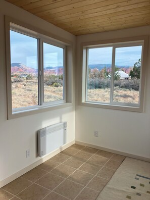 A room with two large windows offering views of a mountainous landscape. - Sunny & Private I bedroom House with Sun Room for Guests (Torrey)