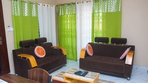 Ein Wohnzimmer mit zwei Sofas, einem Couchtisch und einem Esstisch.