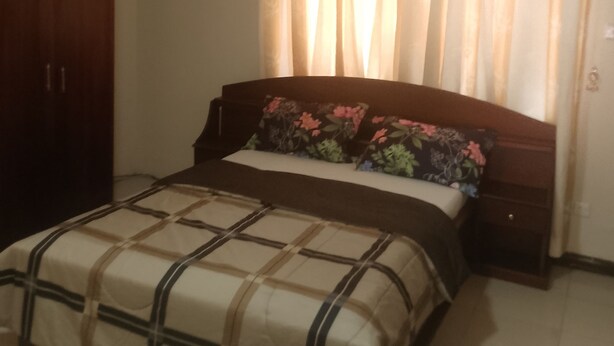 Ein Schlafzimmer mit Bett, Kleiderschrank, Deckenventilator und Klimaanlage.