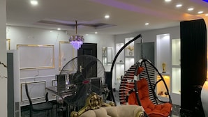 Un interno moderno con zona pranzo, una ventola, un lampadario e un'originale poltrona sospesa.