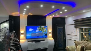 Un soggiorno moderno con una televisione a schermo piatto, un divano confortevole e un pannello decorativo a parete.
