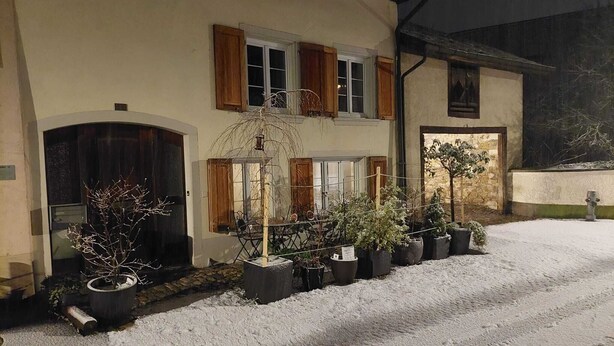 A building with a snow-covered driveway, wooden shutters, and potted plants. - Characteristic 18th-century apartment, hiking groups, families (Waldenburg)