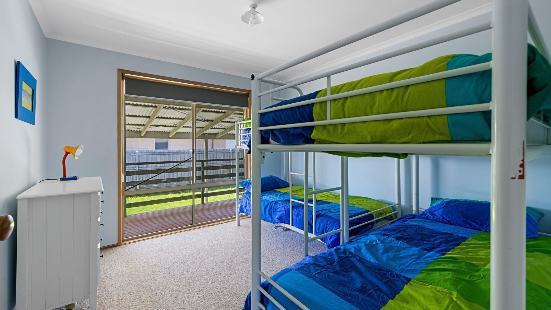 Une chambre avec un lit superposé, un bureau et une fenêtre.