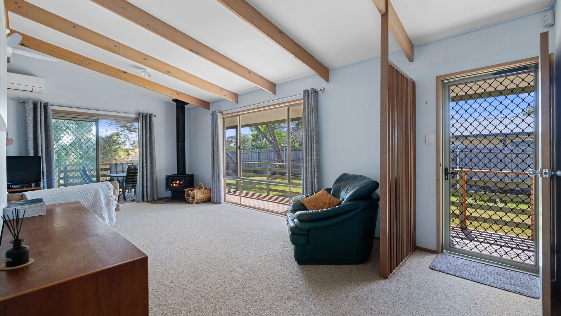 A spacious living room with a fireplace, a sofa, and a TV.