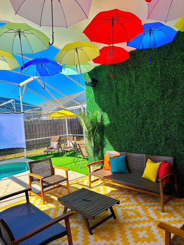Un espace patio aménagé avec du mobilier d’extérieur, une piscine et un mur végétal.