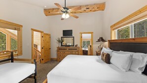 A bedroom with a large bed, a wooden dresser, a ceiling fan, and a window. - 14mcbr3 (Breckenridge)